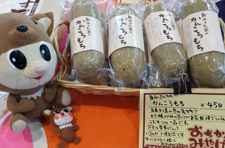 かんころもちとマスコットキャラのぬいぐるみが一緒に写ったお土産屋さんの写真